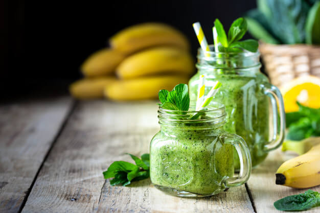 two healthy green smoothies with spinach banana orange mint glass jar ingredients 127032 1462